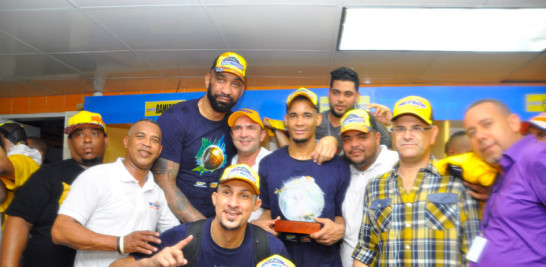 Peter John Ramos, Amaury Filión, otros jugadores y directivos del equipo sostienen la copa de campeón.