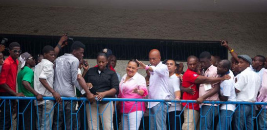 El presidente Michel Martelly, en el centro de la fila con su esposa, Sofía Martelly, saluda a sus seguidores después de emitir su voto en Puerto Príncipe, durante las elecciones parlamentarias de ese país.