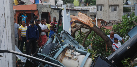 Daños. Residentes observan los restos del fuselaje del helicóptero accidentado y árboles destruidos por el impacto de la aeronave.