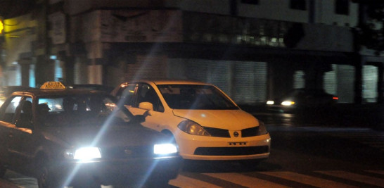 Un vehículo privado circula sin luces por una avenida de la capital.
