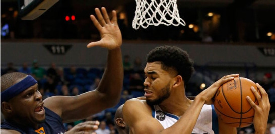 Karl-Anthony Towns, de los Timberwolves de Minnesota, retiene la pelota ante el acoso defensivo de Zach Randolph, de Memphis, durante el partido de ayer en el basket de la NBA.