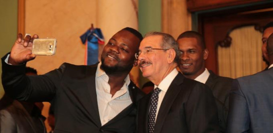 Selfie. Fernando Rodney, el Hombre de la Flecha, se tira una foto junto al presidente Danilo Medina durante la visita del equipo a Palacio ayer. Observa sonriente el relevista zurdo Ramón García.