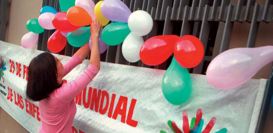 Solidaridad. Una mujer decora un cartel durante una actividad en pro de la equidad para las personas con enfermedades raras.