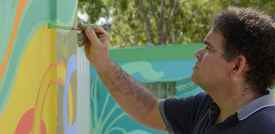 Mural. Paul Santoreli mientras pintaba en la pared de la escuela Emma Balaguer.