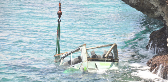 Minibús accidentado mientras una grúa intentaba sacarlo del agua.