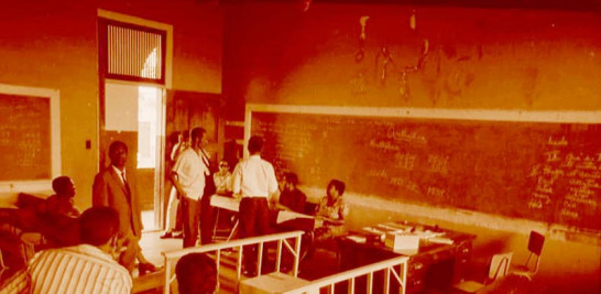 Elecciones 1970. Plano general de un centro de votación, en esta ocasión las urnas eran protegidas con divisiones de madera y cinta "sellada" con adhesiva.