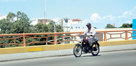 Muy mal ejempo! Un agente de Policía viaja impasible en su motocicleta sobre un elevado, incluso sin el casco que manda la ley.