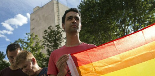 Un joven sostiene una bandera del arcoíris durante la concentración que el colectivo Colegas-Confederación LGBT ha convocado a las puertas de la Embajada de Estados Unidos en apoyo a las víctimas de la matanza ocurrida en el club gay Pulse de Orlando (Florida).