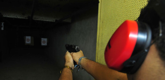 Un ciudadano apunta hacia un lugar fijo donde está su blanco, listo para el disparo, durante un entrenamiento en un polígono para práctica de tiro, habilitado en la capital.