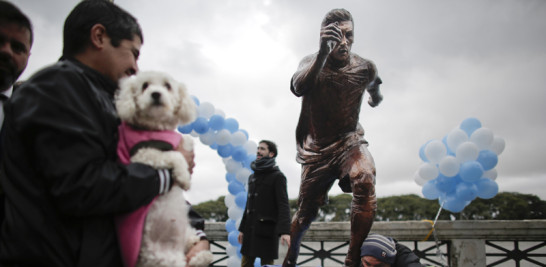 Un aficionado besa la estatua de Lionel Messi que fue presentada el martes 28 de junio del 2016 en Buenos Aires. La estatua es parte de una campaña que busca convencer a Messi de que regrese a la selección argentina, a la que renunció tras perder a final de la Copa América Centenario. (AP Photo/Victor R. Caivano)