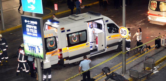 Ataque. Médicos y forenses trabajan en una escena con víctimas después de un ataque suicida con bomba ayer en Estambul.