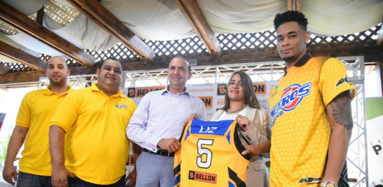 Larissa Pimentel, de la ferretería Bellón, entrega una camiseta del equipo Metros a Mícalo Bermúdez y el jugador Víctor Liz.