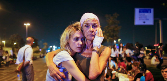 Dos pasajeras se abrazan mientras esperan ante el aeropuerto de Atartuk, en Estambul, en la madrugada del miércoles 29 de junio de 2016. / AP