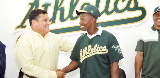 Raymond Abréu, vicepresidente de operaciones para América Latina, estrecha la mano
de Lázaro Armenteros, cubano firmado por los Atléticos de Oakland.