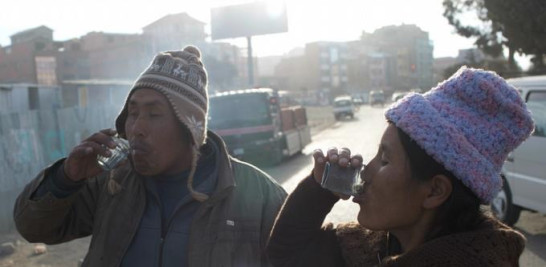 En imagen del 8 de junio de 2016, Lorenzo Saldías y su esposa beben leche de burra de un vendedor en las calles de El Alto, Bolivia. La leche de burra es medicamento que sana. Estaba mal de pulmonía, me dolía la espalda y estaba resfriado. Ahora me está haciendo efecto, aseguró Saldías. (AP Foto/Juan Karita)