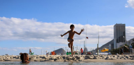 VIDA DIARIA. Dos niños bromean en la playa de Copacabana, una de las más populares del mundo.