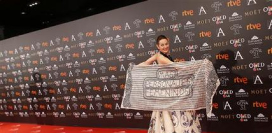 La actriz Uca Escribano posa en la alfombra roja de los Premios Goya con un chal en el que pide "más personajes femeninos", el sábado 4 de febrero del 2017 en Madrid. (AP Foto/Francisco Seco)