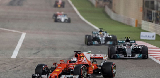 El alemán Sebastian Vettel, de Ferrari, al centro, celebra al ganar el Gran Premio de Fórmula Uno de Bahrein.