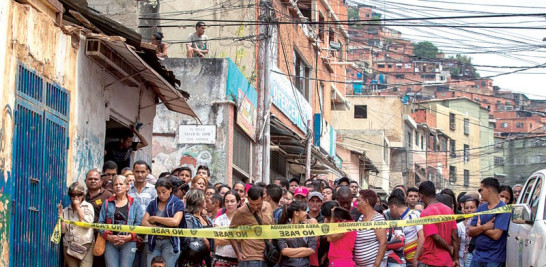Barrio. Docenas de personas permanecen a las afueras de una panadería saqueada anoche en Venezuela.