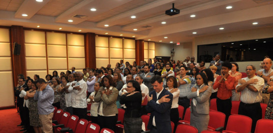 Participantes en la conferencia del padre Leonel Narváez se abrazan durante una dinámica realizada por el religioso.