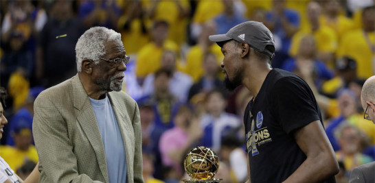El delantero del Golden State Warriors, Kevin Durant, le da la mano a Bill Russell mientras le entrega el premio al Jugador Más Valioso de la Final de la NBA.