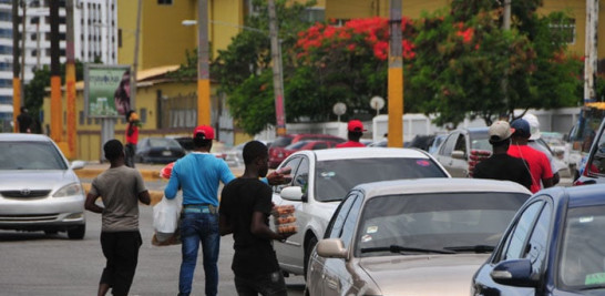 Arrabalización. Como enjambre abordan a los conductores de vehículos los vendedores informales haitianos en la avenida 27 de Febrero con Isabel Aguiar, en el lugar conocido como Pintura.