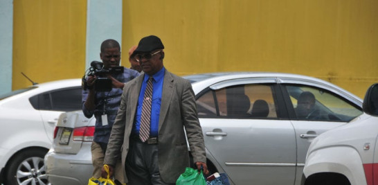 Un hombre no identificado carga bultos con pertenencias de uno de los imputados que abandonó ayer el penal de Najayo.