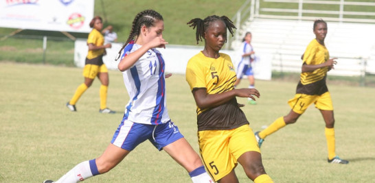 La dominicana Alissa Jazmine Oviedo, disputa el balón a una jugadora de Antigua durante el partido disputado este miércoles en el estadio Panamericano de San Cristóbal.