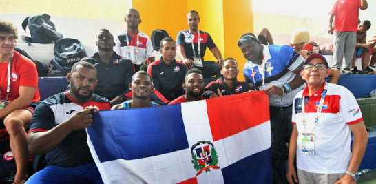 Nelson Ramírez, Jefe de Misión, junto a los atletas de lucha exhibiendo la bandera de la República Dominicana.