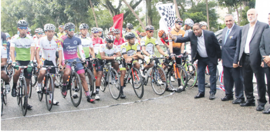Danilo Díaz, Ministro de Deportes al momento de otorgar el banderazo de honor que dejó inaugurada la versión 39 de la Vuelta Ciclista Independencia. Figuran Luis mejía Oviedo, Antonio Acosta y Jorge Blas Díaz, además de gran parte del pelotón de pedalistas.
