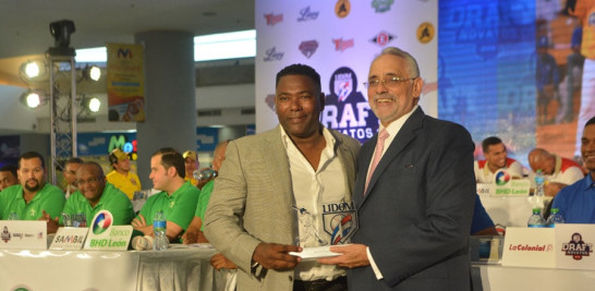 Miguel Tejada, ex extelar de Grandes Ligas y del béisbol dominicano al momento de recibir una placa por parte de Vitelio Mejía, presidente de la Liga de Béisbol durante la realización del sorteo de noatos.