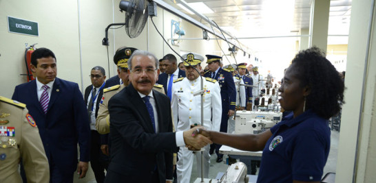 Fábrica de uniformes. El presidente Danilo Medina saluda al personal de la zona franca industrial de San Cristóbal, la que recorrió luego de dejar abierta la Industria Militar en esta ciudad.