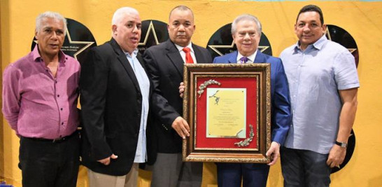 Rolando Sebelén recibe una placa de reconocimiento de manos de Carlos Campusano, Franklin Peña, Jony Mateo y José M. Peña.