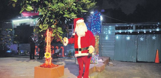 Este Santa Claus colocado en la entrada "interpreta" temas navideños
