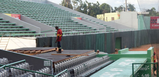 Un obrero labora en la instalación de la plataforma que servirá de base a nuevos asientos detrás del dogout de visitantes de ese parque