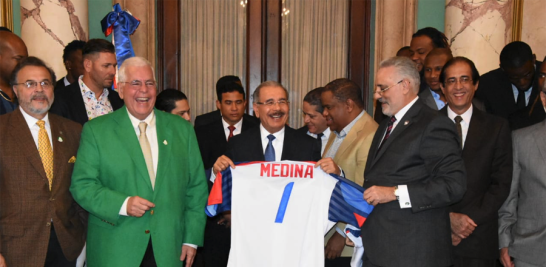 Detalle. El presidente de la Liga de Béisbol, Vitelio Mejía, entrega una réplica de la chaqueta que usará el equipo dominicano en la serie.