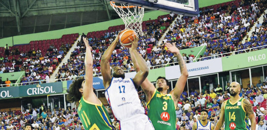 Ronald Roberts, de República Dominicana, se eleva en busca de un canasto ante la defensa de Anderson Varejao y Lucas Dias, de Brasil, en acción del partido de anoche en la sexta y última ventana de la FIBA para la Copa Mundial de Baloncesto que se celebrará en el verano en China.