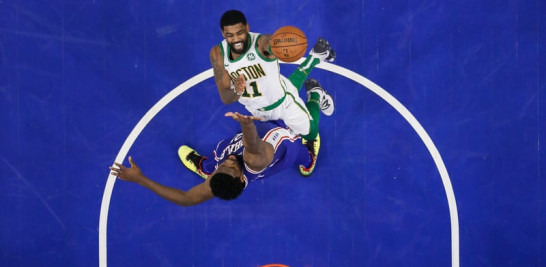 Kyrie Irving se disputa el balón con Joel Embiid en el partido que los Sixers se impusieron a los Celtics con marcador de 118-115. /AP