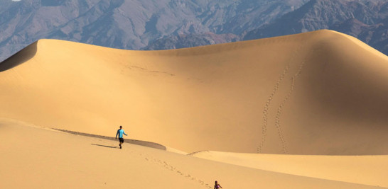 Dos turistas caminan por las dunas de Mesquite.