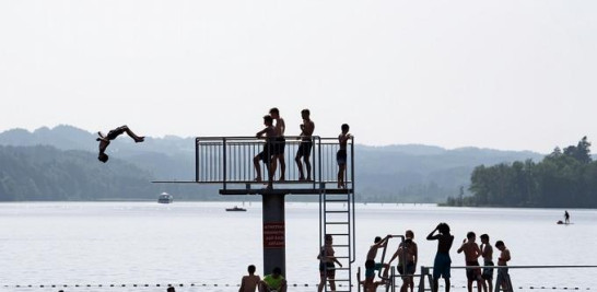 Jóvenes saltan al agua del lago Staffel en Mnsing (Alemania). EFE/ Lukas Barth-Tuttas