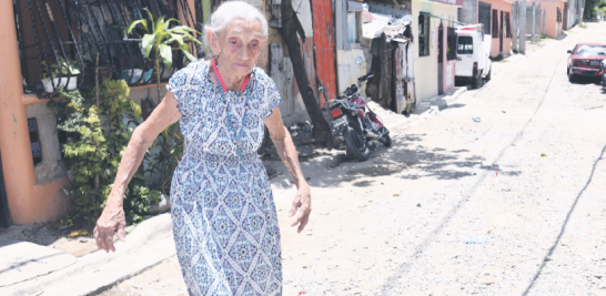 Doña María Celestina Veloz Cruz suele caminar sola por el sector y para ir a la iglesia. Ora para que arreglen las calles. ADRIANO ROSARIO/LD