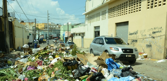 Basura acumulada en calle Imbert, mientras un vehículo pasa con dificultad por el pequeño espacio libre de desechos. / Foto: José Alberto Maldonado