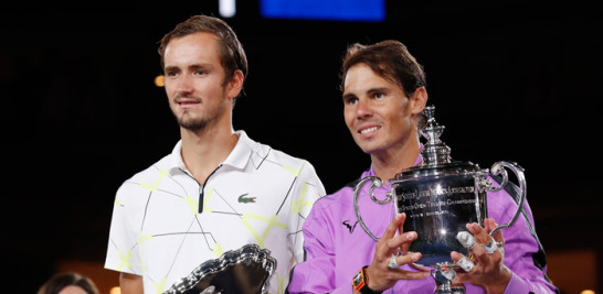 Rafael Nadal y Daniil Medvedev posan con sus trofeos luego de su épico encuentro.
