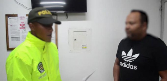 Un oficial de Policía lee los cargos a El Abusador, como paso formal y legal durante su arresto ayer en Colombia.
