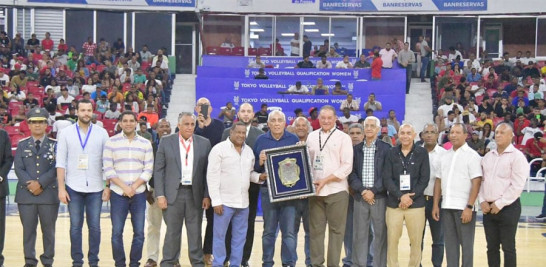 Osiris Duquela a quien está dedicado el torneo de baloncesto recibe una placa de reconocimiento de Alejandro Montras, administrador de la CAASD.