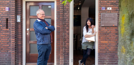 De pie en el pueblo neerlandés de Baarle-Nassau, Willem van Gool, funcionario de turismo local, conversa con Sylvia Reijbroek, cuya galería de arte se encuentra en el poblado belga de Baarle-Hertog, el 2 de mayo de 2020 (Ilvy Njiokiktjien/The New York Times).