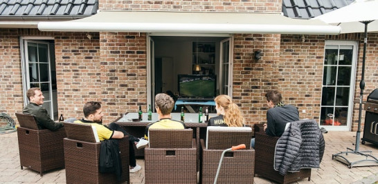 Unos amigos ven un partido de fútbol por televisión en la casa de Sven y Vanessa Jundel en Dortmund, Alemania, el 16 de mayo de 2020. (Felix Schmitt/The New York Times)
