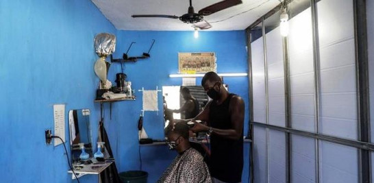 Foto de Carlos Alberto Lopes da Silva corta el pelo a un hombre en Río de Janeiro para obtener ingresos. Fuente: Diario1.