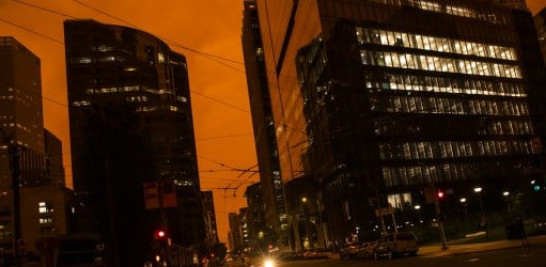 Un resplandor naranja se ve sobre una oscura calle Howard mientras el humo de varios incendios forestales que arden en el norte de California se mezcla con la capa marina en San Francisco, California. Foto: Philip Pacheco/AFP.