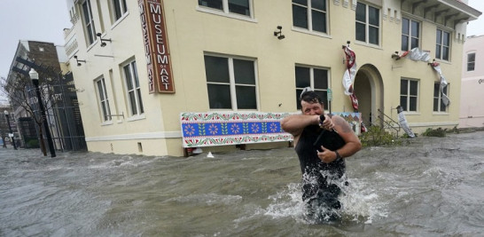 Un hombre vadea una calle inundada en Pensacola, Florida. Foto: AP/Gerald Herbert.
